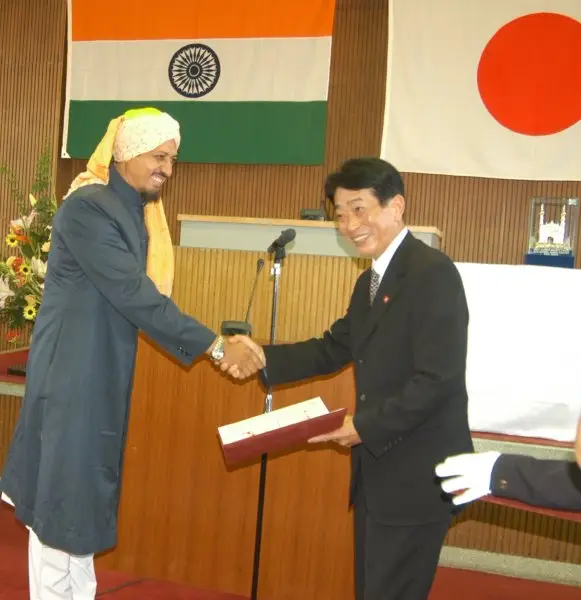 An award ceremony with the flags of India and Japan